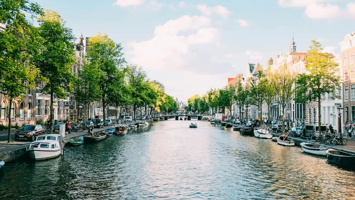 Canal de Ámsterdam con casas holandesas y bote turístico